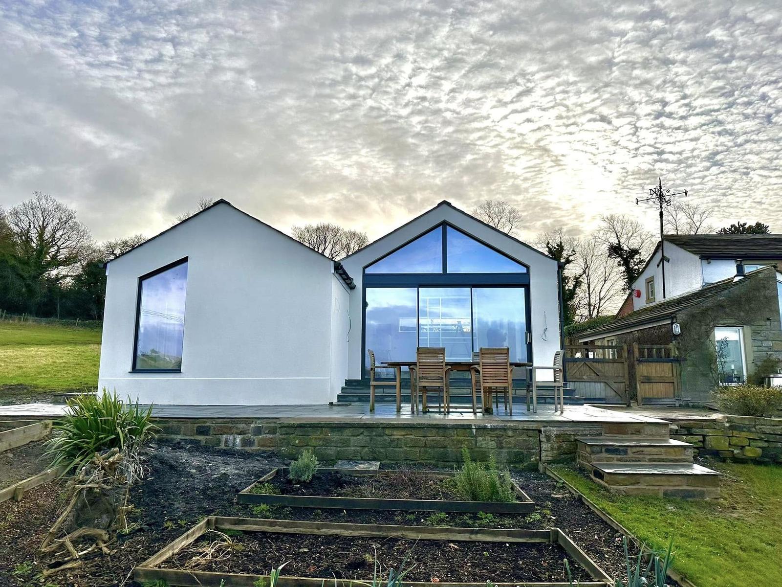White rendered new build with a fully glazed gable